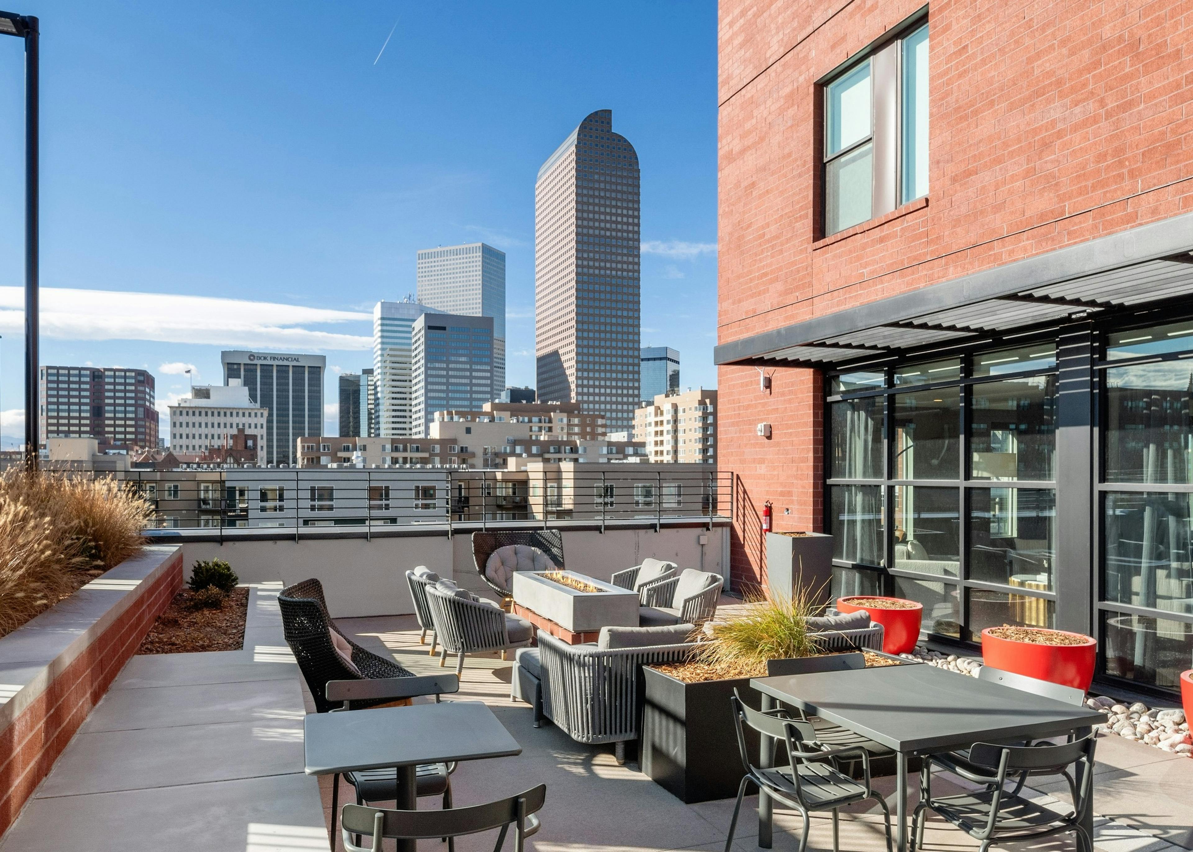 Rooftop lounge amenity space at AMLI at Uptown apartment community featuring ample seating options surrounded by city views