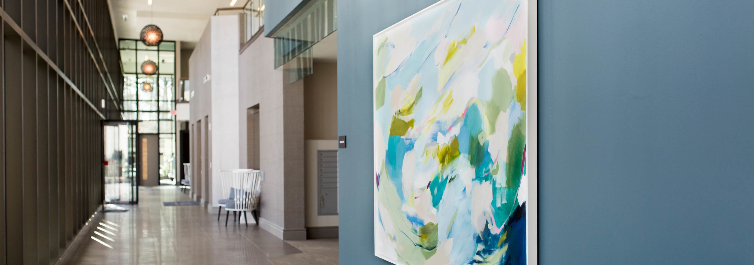 Alternate view of the lobby at AMLI 3464 with beige flooring and raised ceilings with glass doors down the hallway