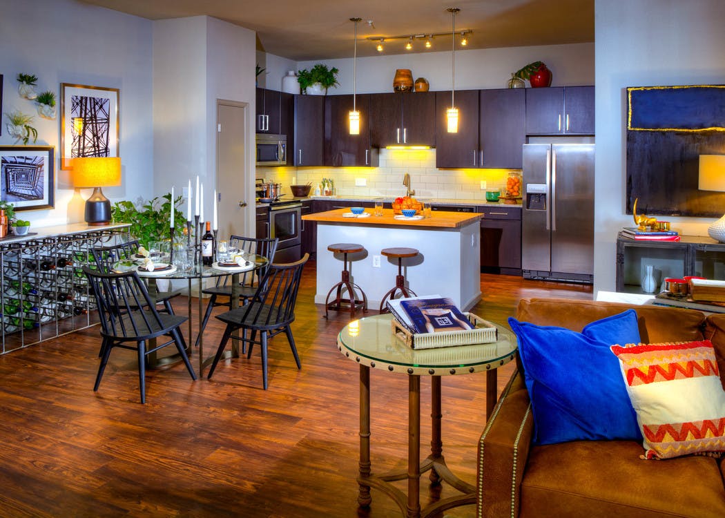 Interior view of a living room and kitchen at AMLI Denargo Market apartments with a dining room table and chairs and lamps