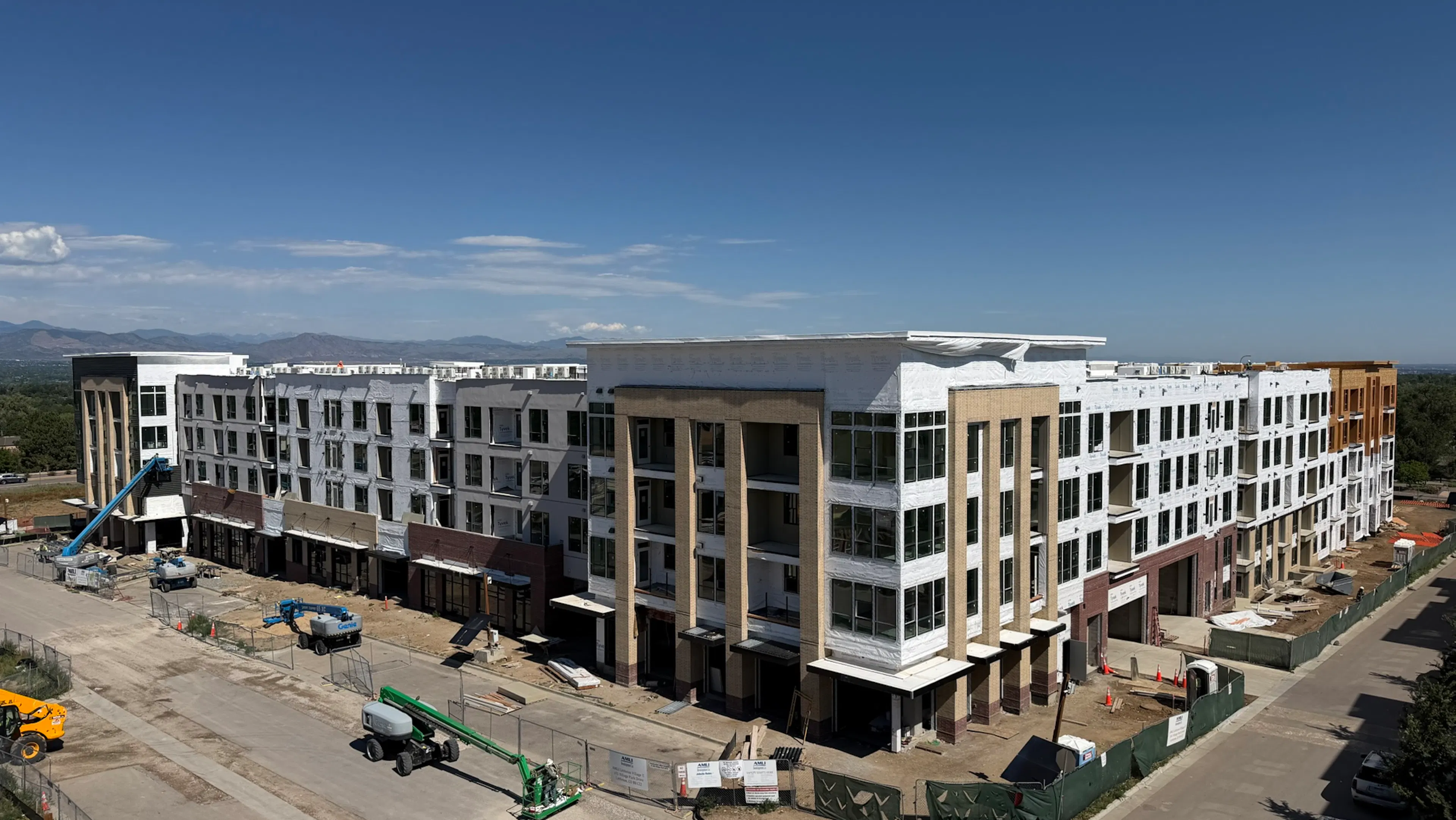 Aerial view of AMLI Village Park apartment community with the leasing brocks and storefront windows complete