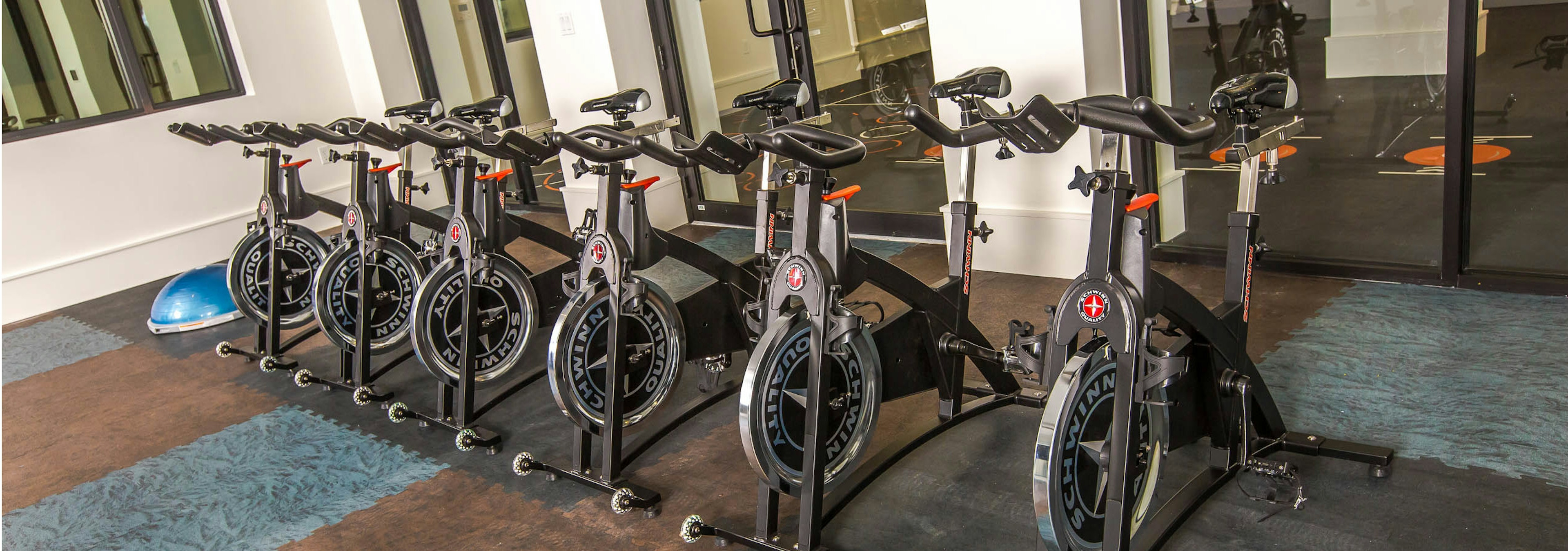 Interior of spinning room at AMLI Joya with multiple spin bikes and full mirrored wall 