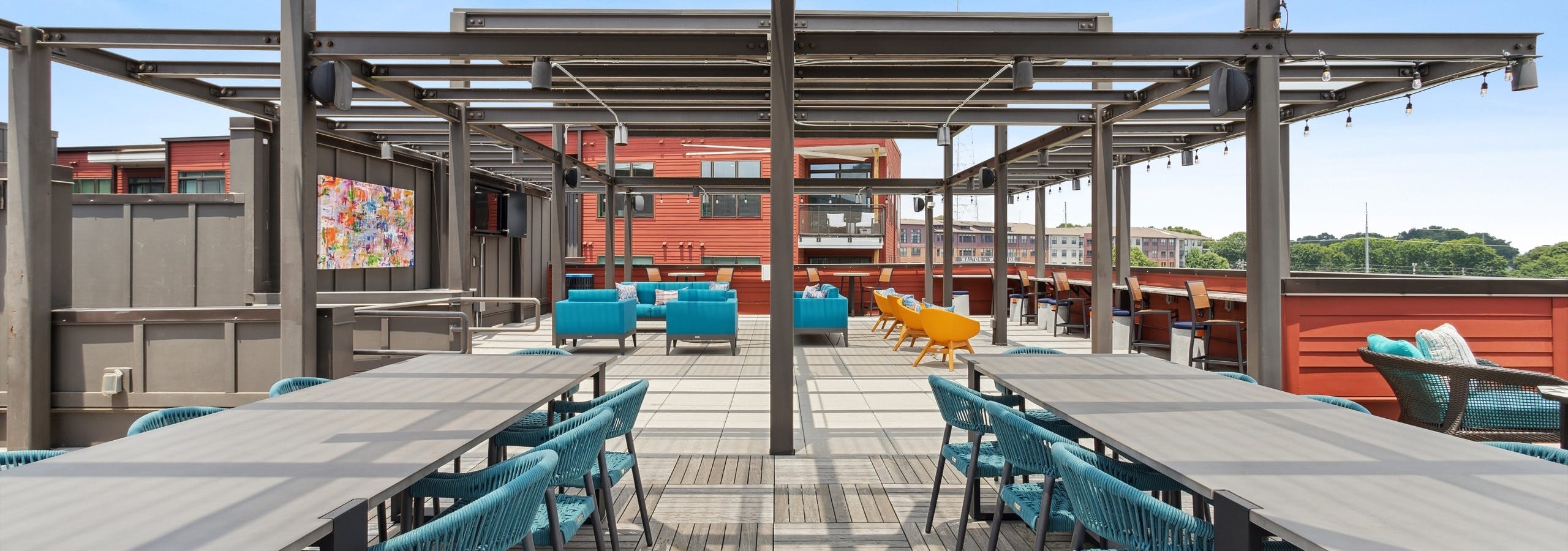 Exterior daytime view of expansive rooftop lounge at AMLI Westside with a variety of seating arrangements and flat screen TVs