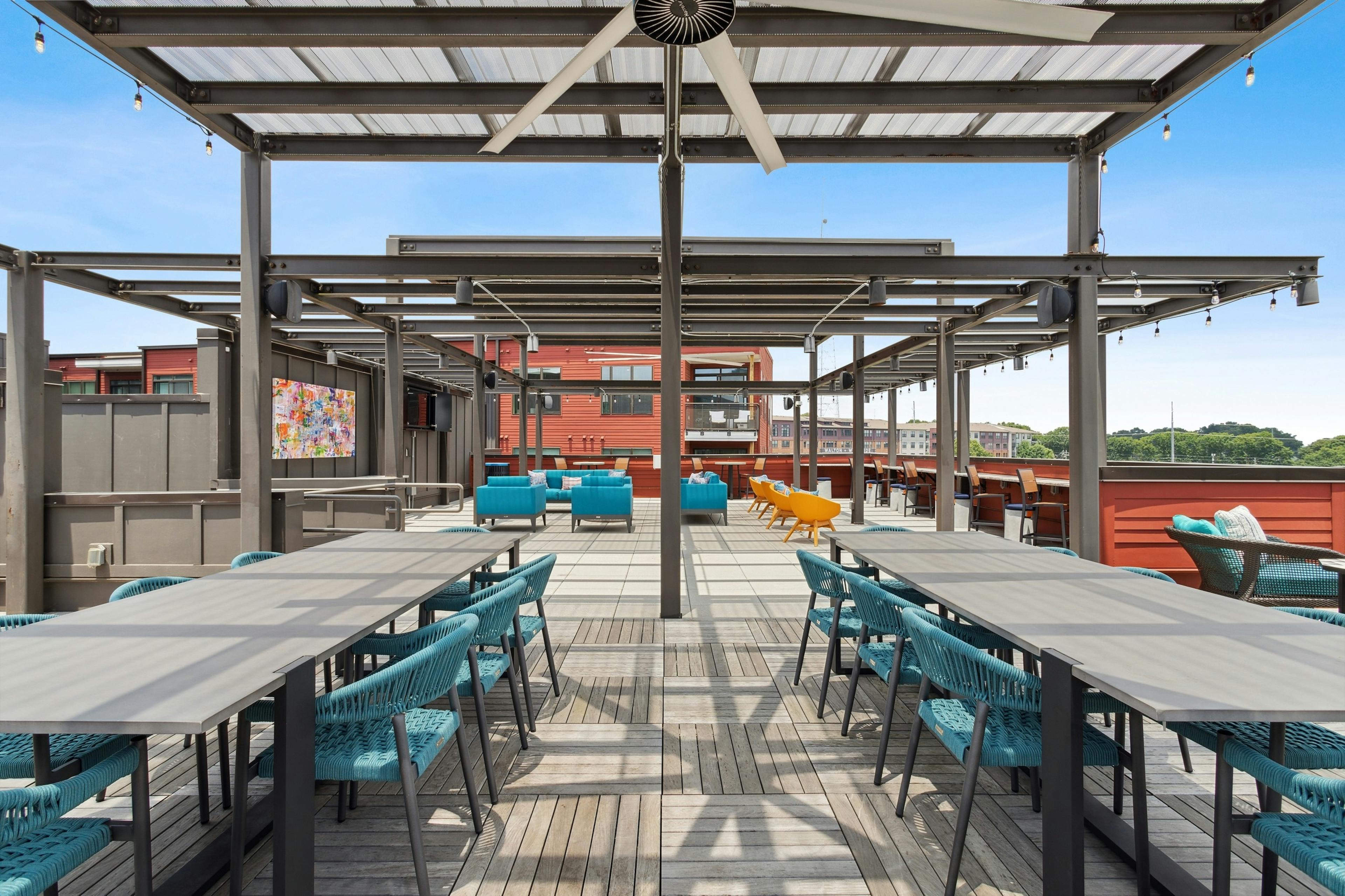 Exterior daytime view of expansive rooftop lounge at AMLI Westside with a variety of seating arrangements and flat screen TVs