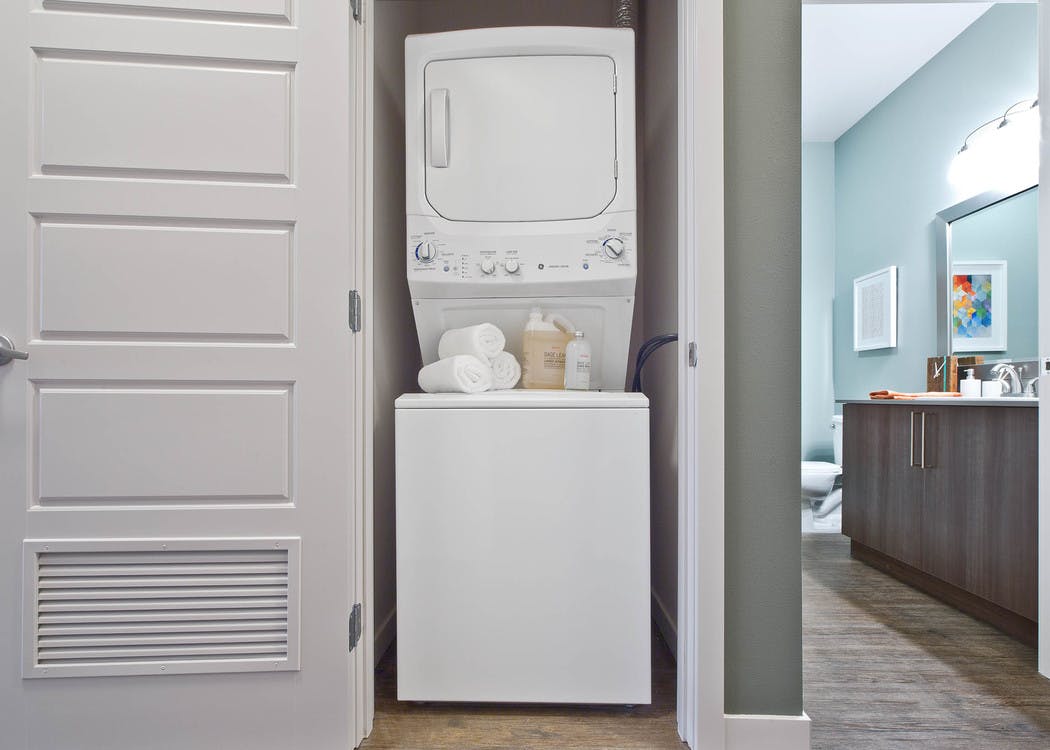 Stacked washer and dryer in a dedicated laundry closet at AMLI South Lake Union apartments