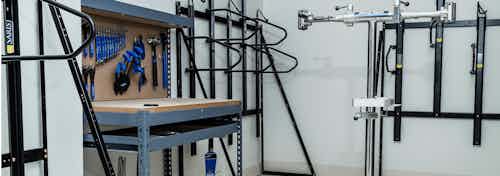 A bike repair room at AMLI Arista apartments with view of a work station table with several tools and multiple bike racks