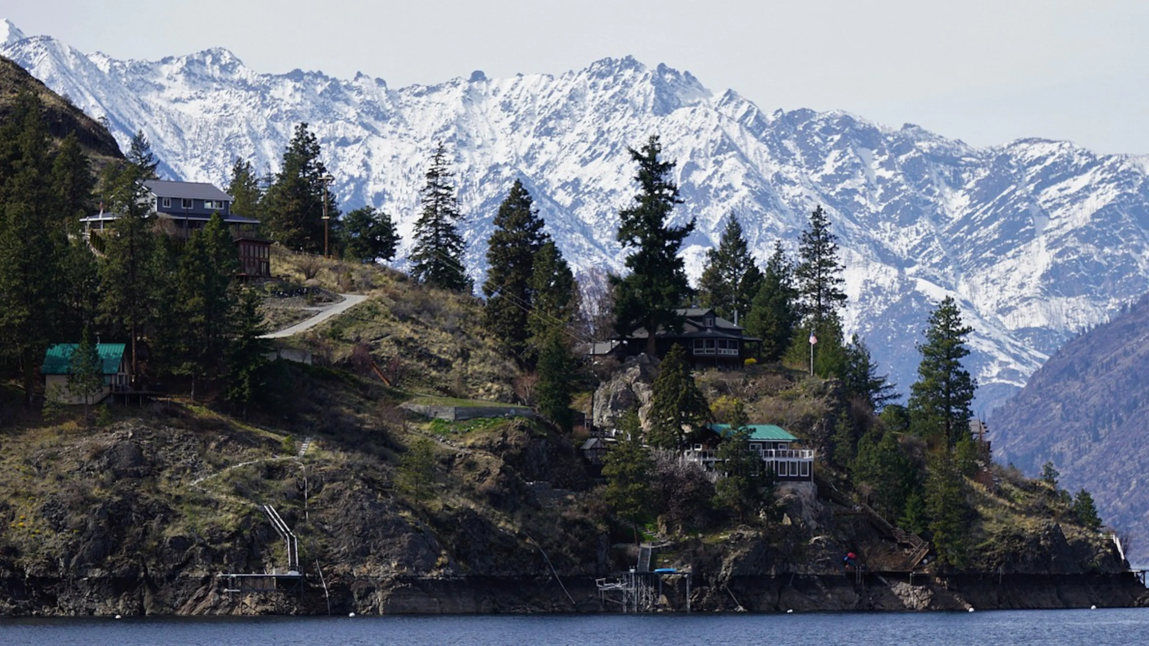 The shores of Lake Chelan in Washington with towering snowy mountains in the background