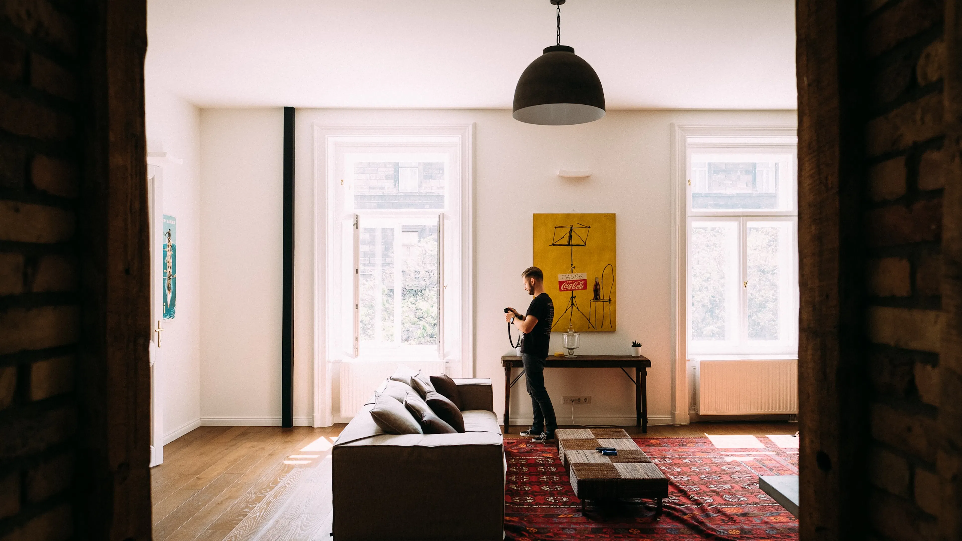 man in brick apartment looking at a camera