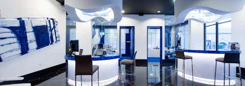 Interior of AMLI Uptown leasing office with computer stations and offices and blue and white decorating with black floors