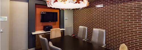 Interior close up view of AMLI RidgeGate conference room with large wood table and chairs equipped with big screen TV and printer