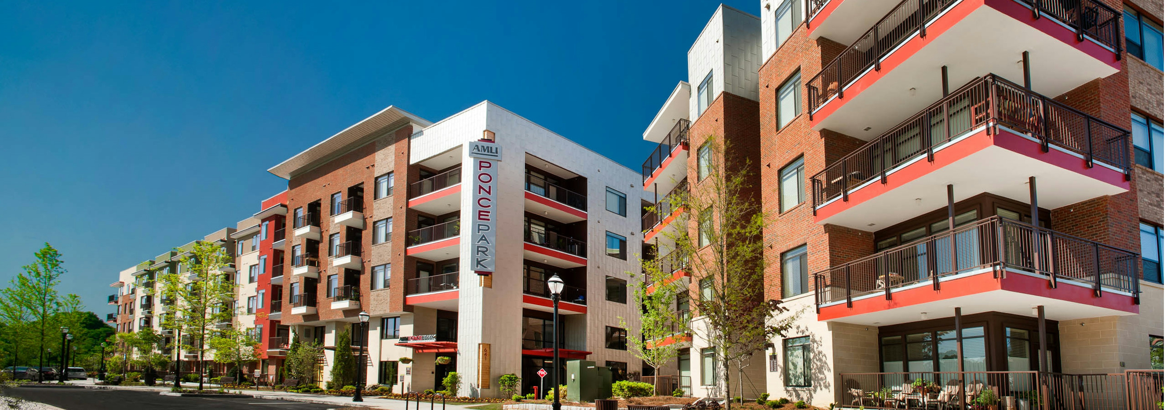 Exterior view of AMLI Ponce Park apartment showcasing two separate buildings both five stories with large corner balconies 