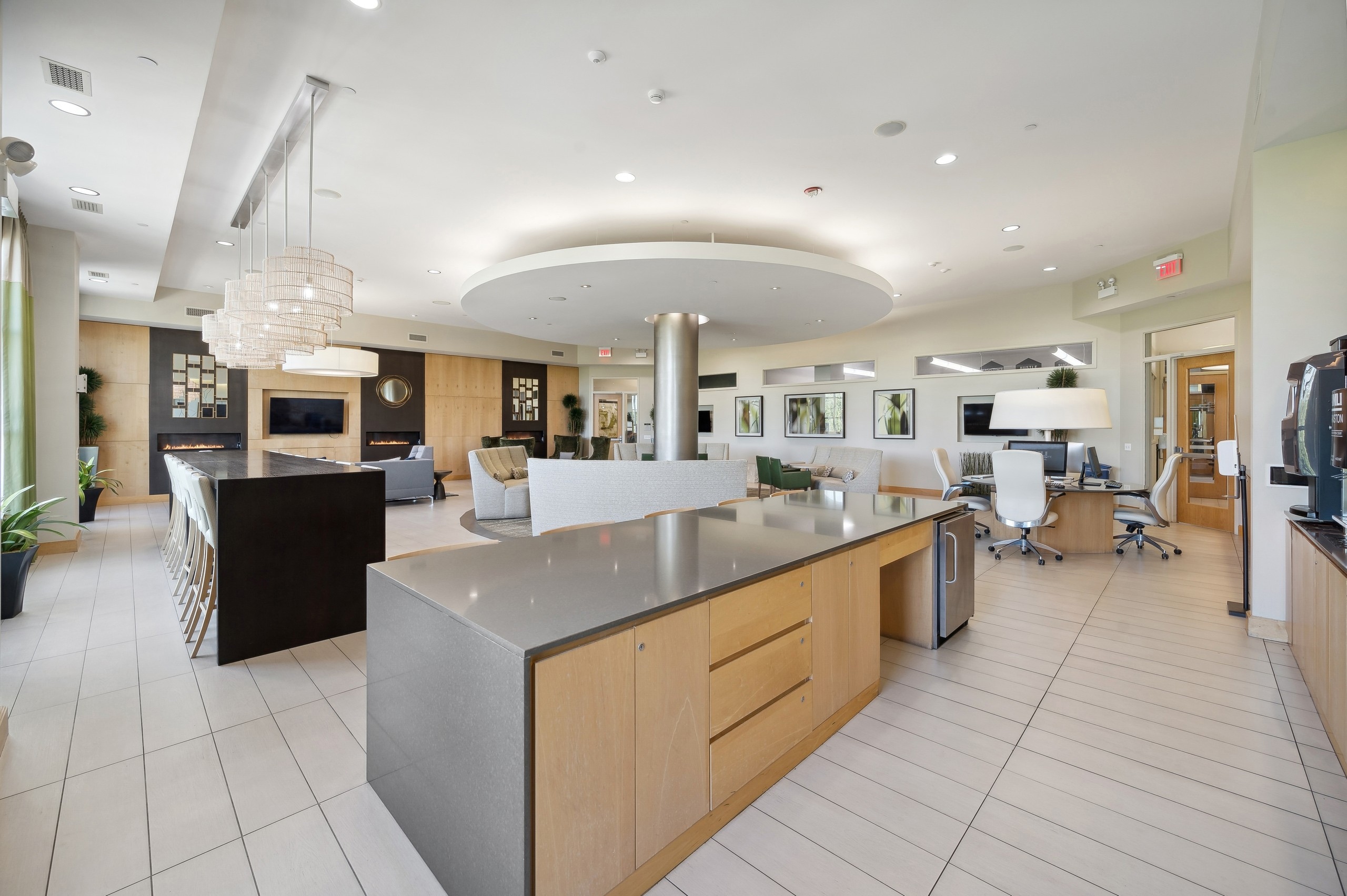 Wide angle view of AMLI Evanston resident lounge including serving kitchen area and business center and various seating