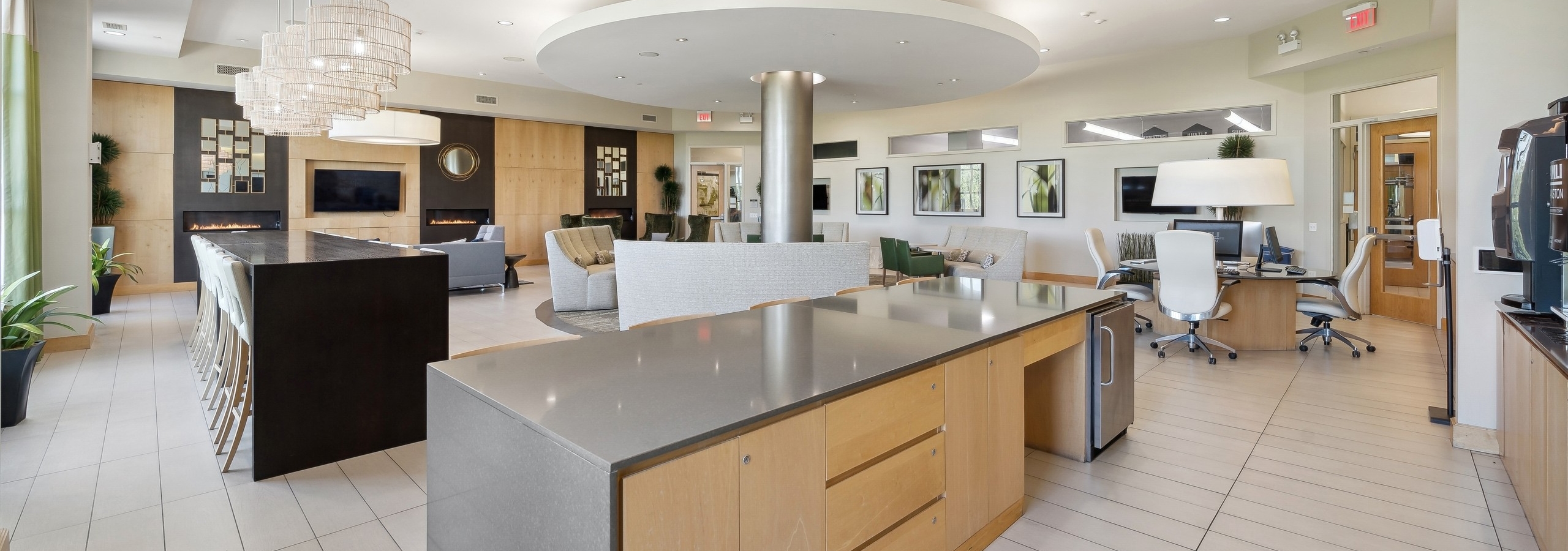 Wide angle view of AMLI Evanston resident lounge including serving kitchen area and business center and various seating