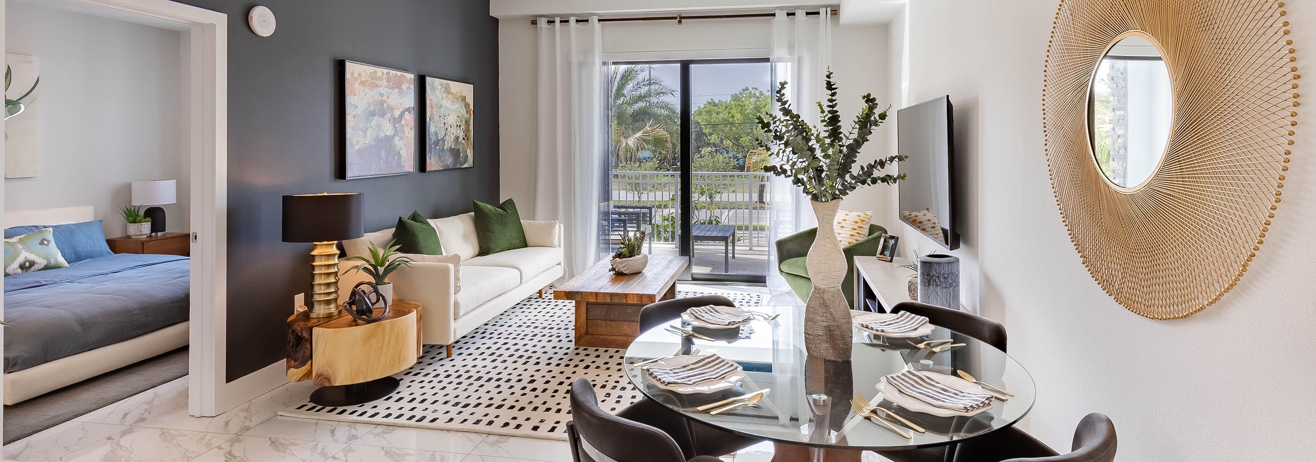 AMLI Park West apartment with dining table and 4 chairs and white sofa and wood coffee table and sliding glass door to patio