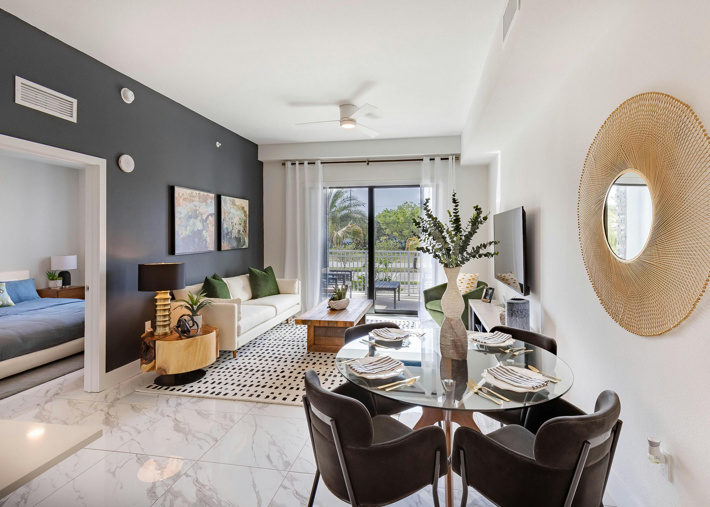 AMLI Park West apartment with dining table and 4 chairs and white sofa and wood coffee table and sliding glass door to patio