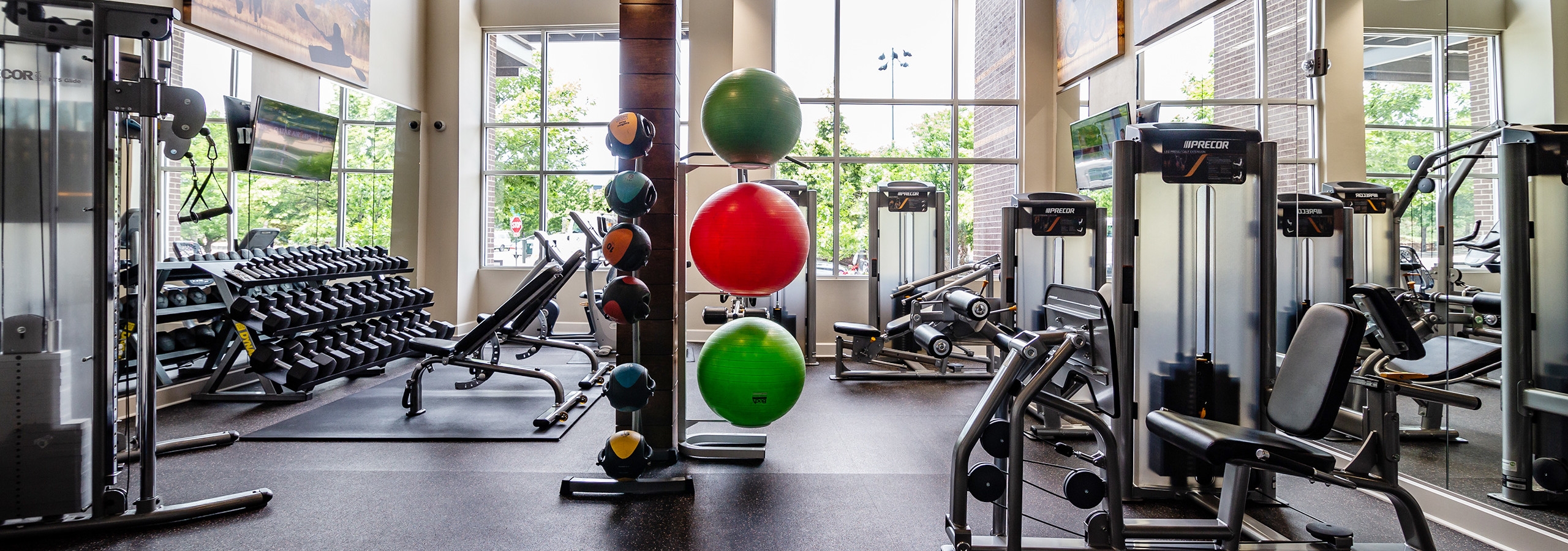 Interior of the fitness center at AMLI Riverfront Park apartments with medicine balls and a variety of workout equipment