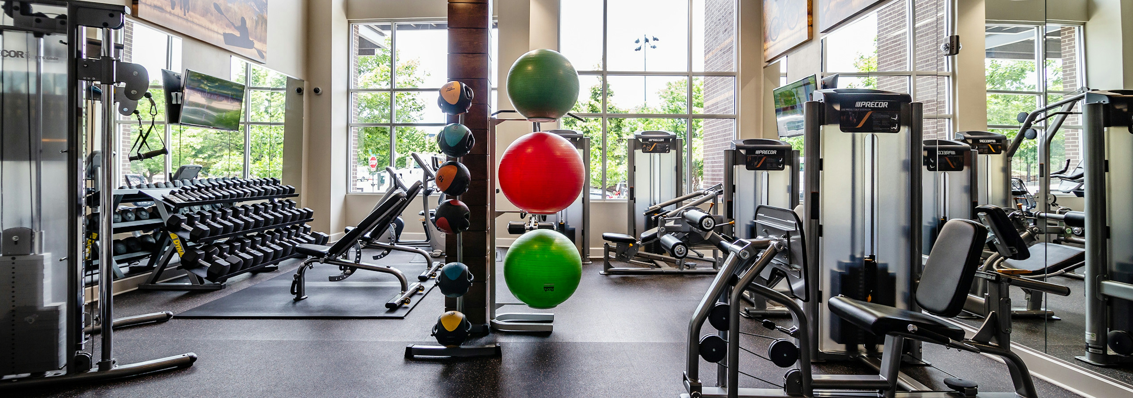 Interior of the fitness center at AMLI Riverfront Park apartments with medicine balls and a variety of workout equipment 