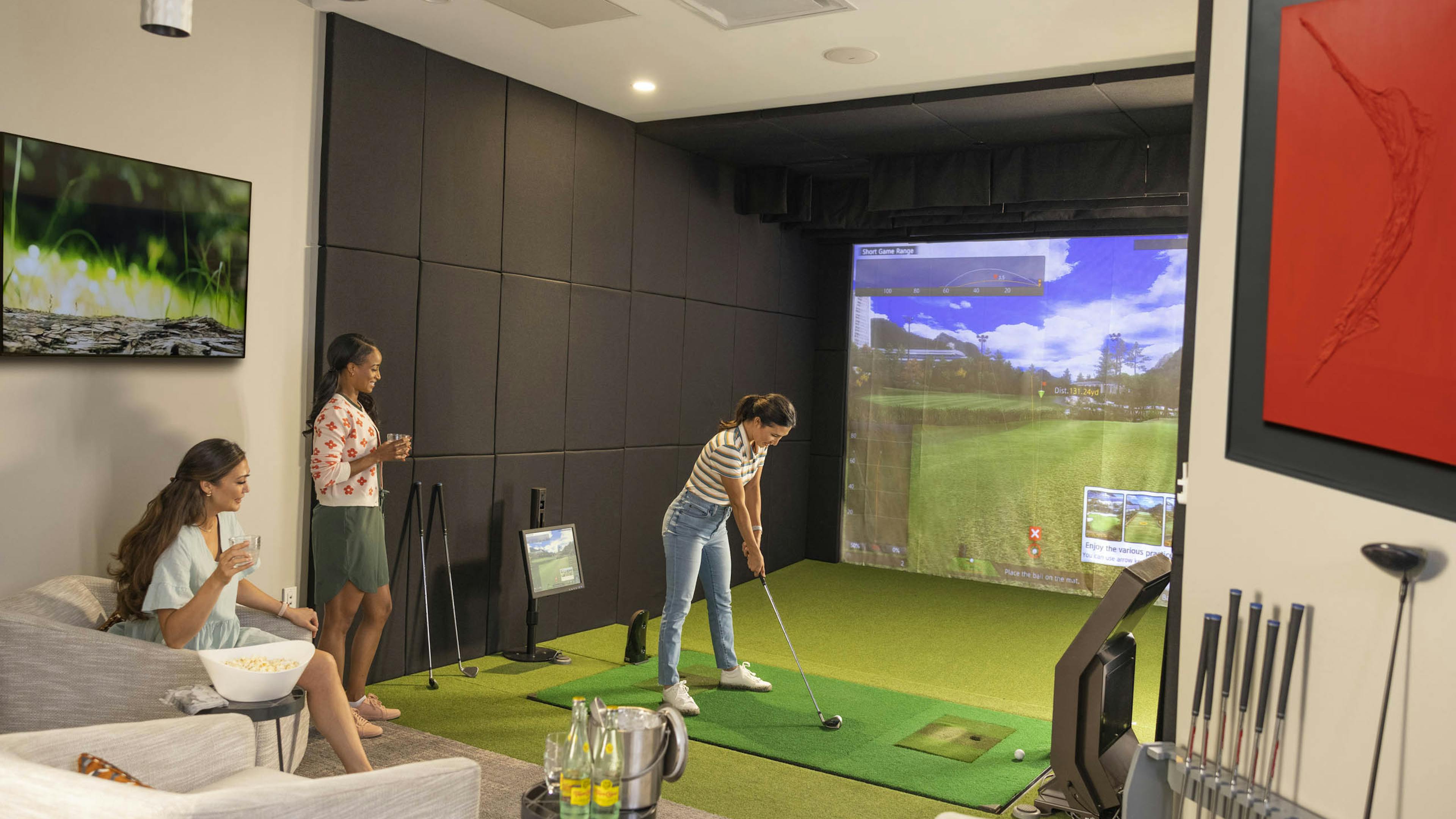 View of three girlfriends enjoying world class GOLFZON simulator and carbonated drinks at AMLI Fountain Place apartments