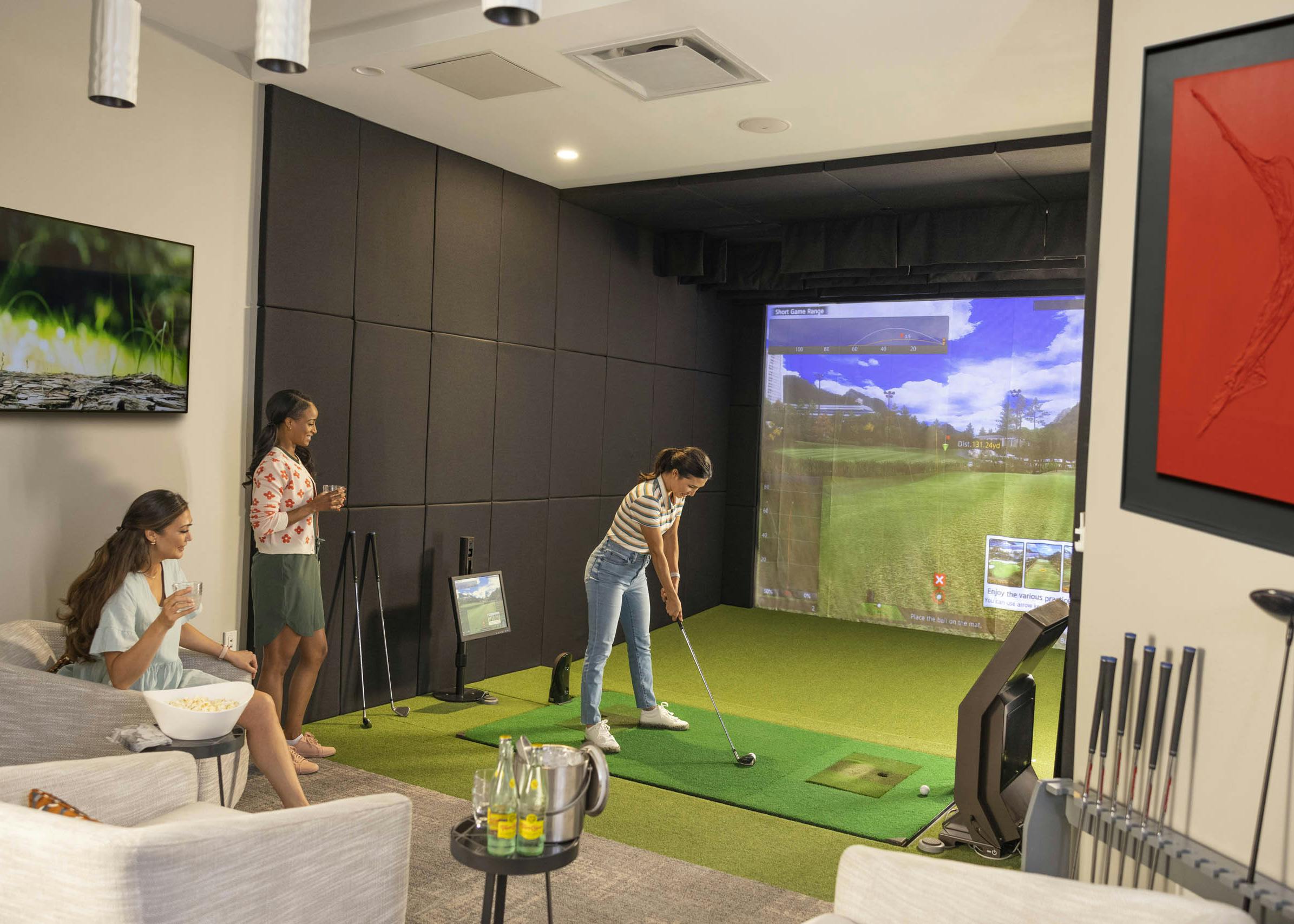 View of three girlfriends enjoying world class GOLFZON simulator and carbonated drinks at AMLI Fountain Place apartments