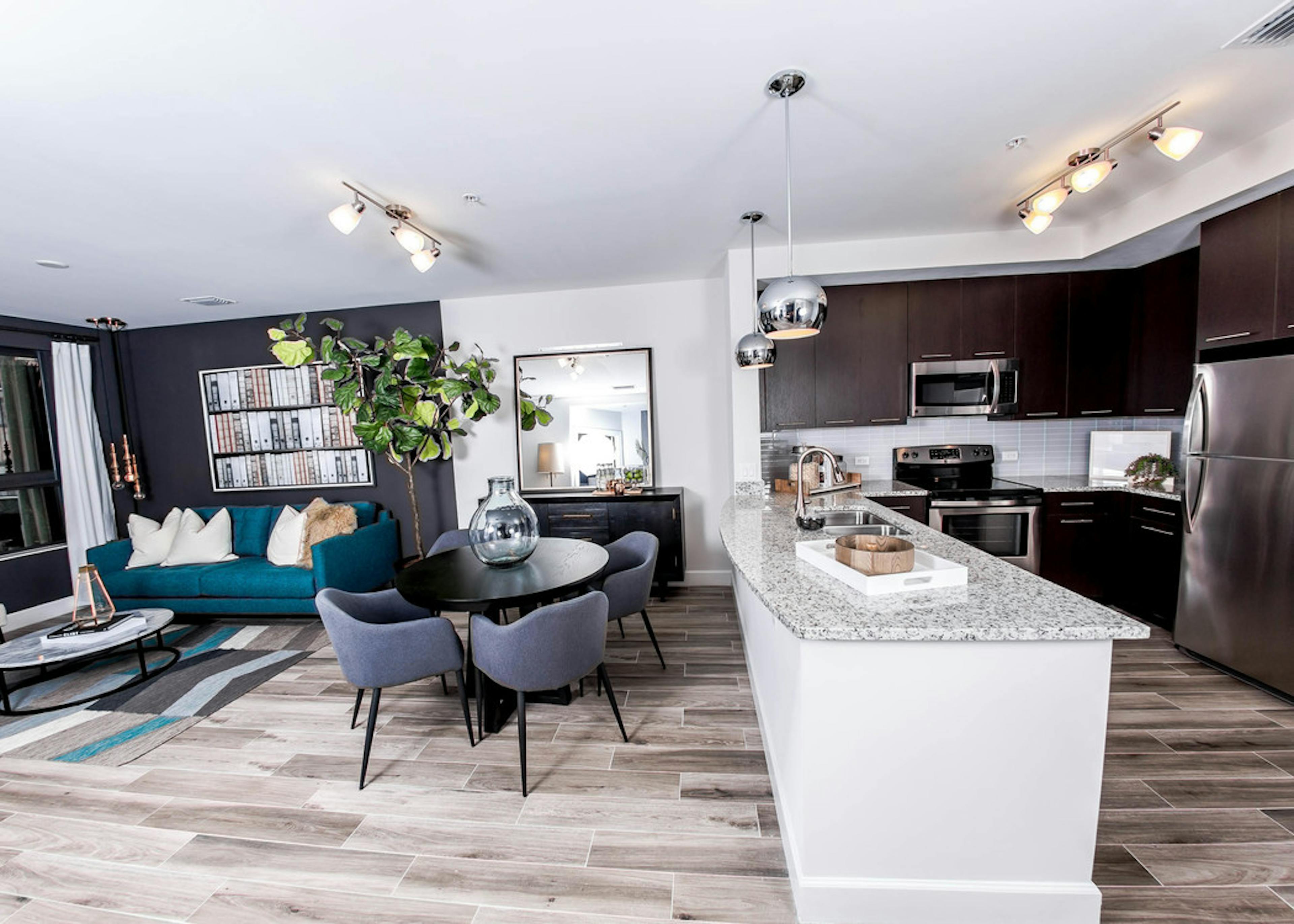  An AMLI Joya apartment contemporary living area and kitchen with stainless steel appliances and dark cabinetry