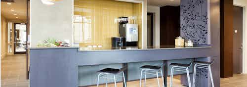 Close up of AMLI West Plano java cafe with a blue grey counter and black barstools with coffee machine and ample counterspace
