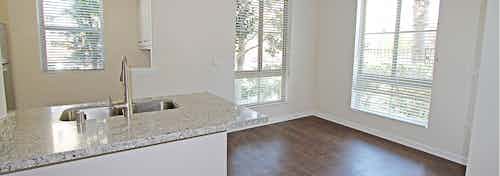 Interior daytime view of AMLI Warner Center apartment kitchen and breakfast nook with hardwood floors and large windows