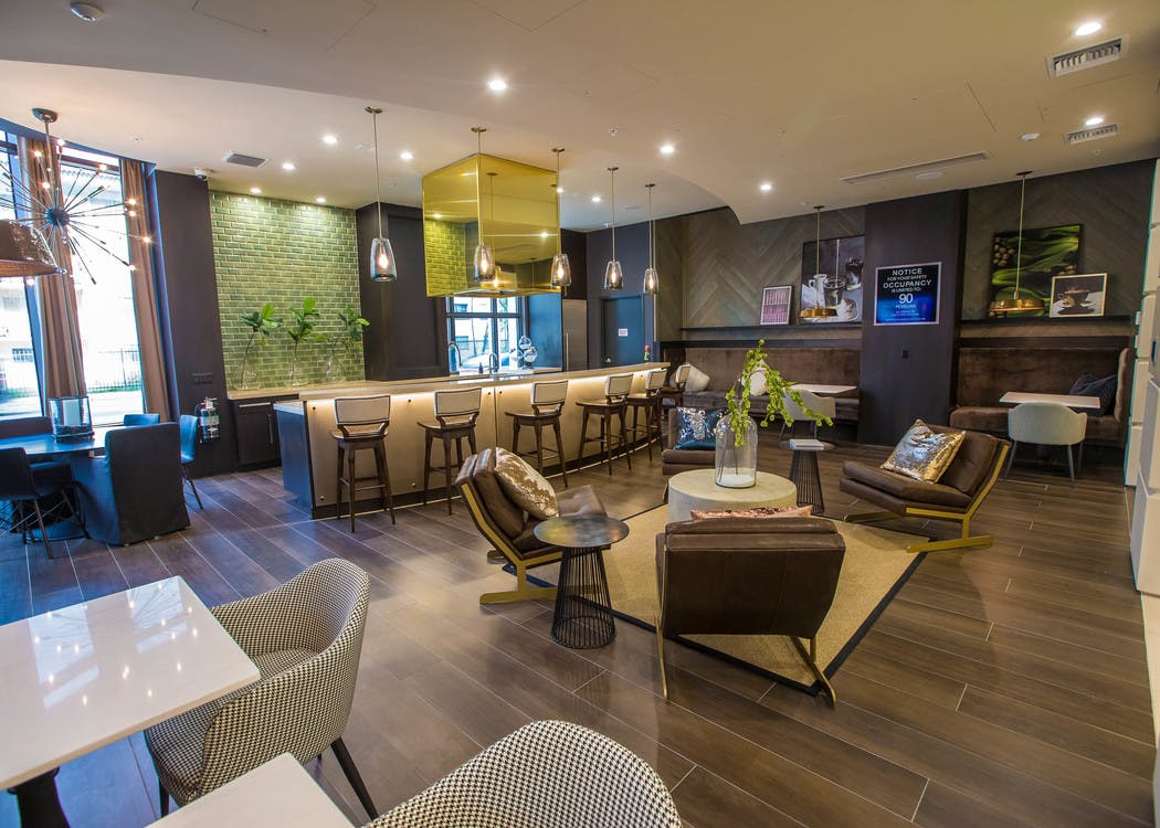 Main resident lounge at AMLI Joya with contemporary living room décor and furniture, electric fireplace and mounted TV