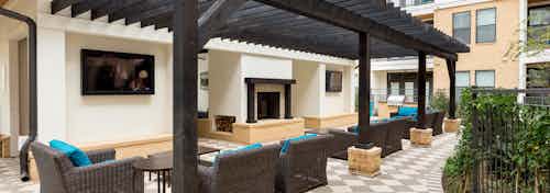 Daytime view of AMLI Campion Trail cabana with comfortable seating and serving bar overlooking pool area with lounges