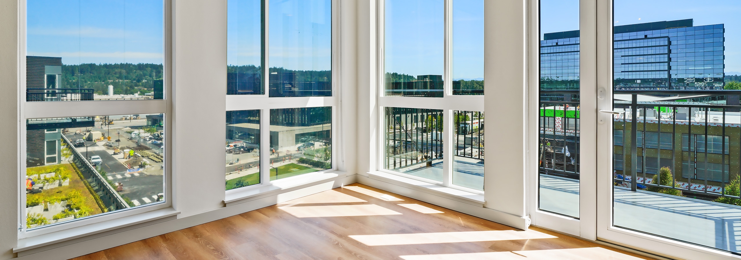 AMLI Spring District apartment living room with large windows and wood floors and balcony with a view of the Spring District