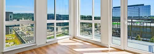 AMLI Spring District apartment living room with large windows and wood floors and balcony with a view of the Spring District