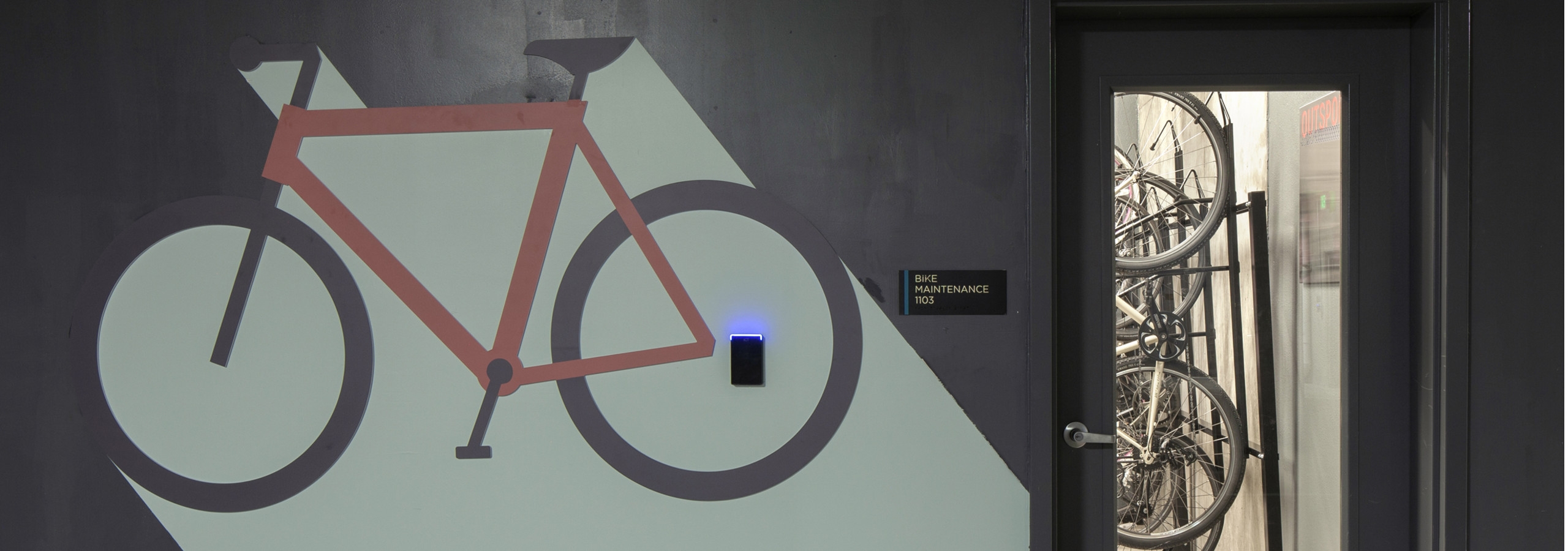 Bike repair room at AMLI Riverfront Green apartments with view of glass entry way door and Bike repair room signage