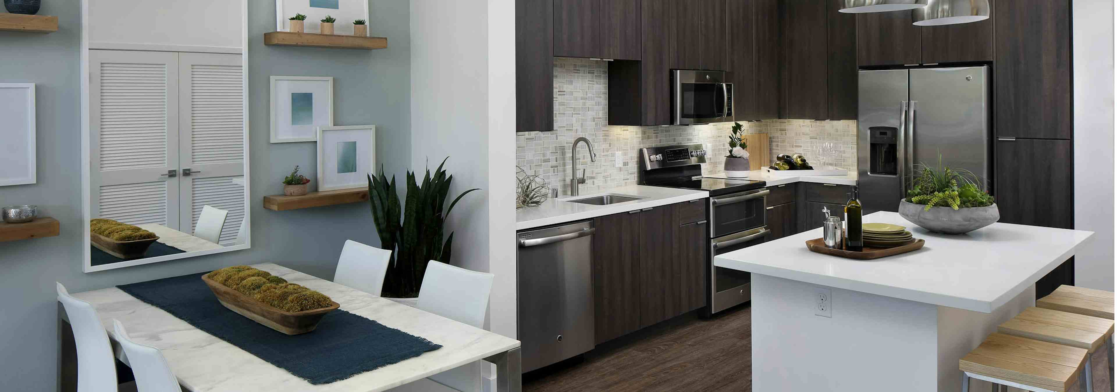 Interior of AMLI Uptown Orange apartment kitchen Island with quartz counters and stainless steel appliances and dining table