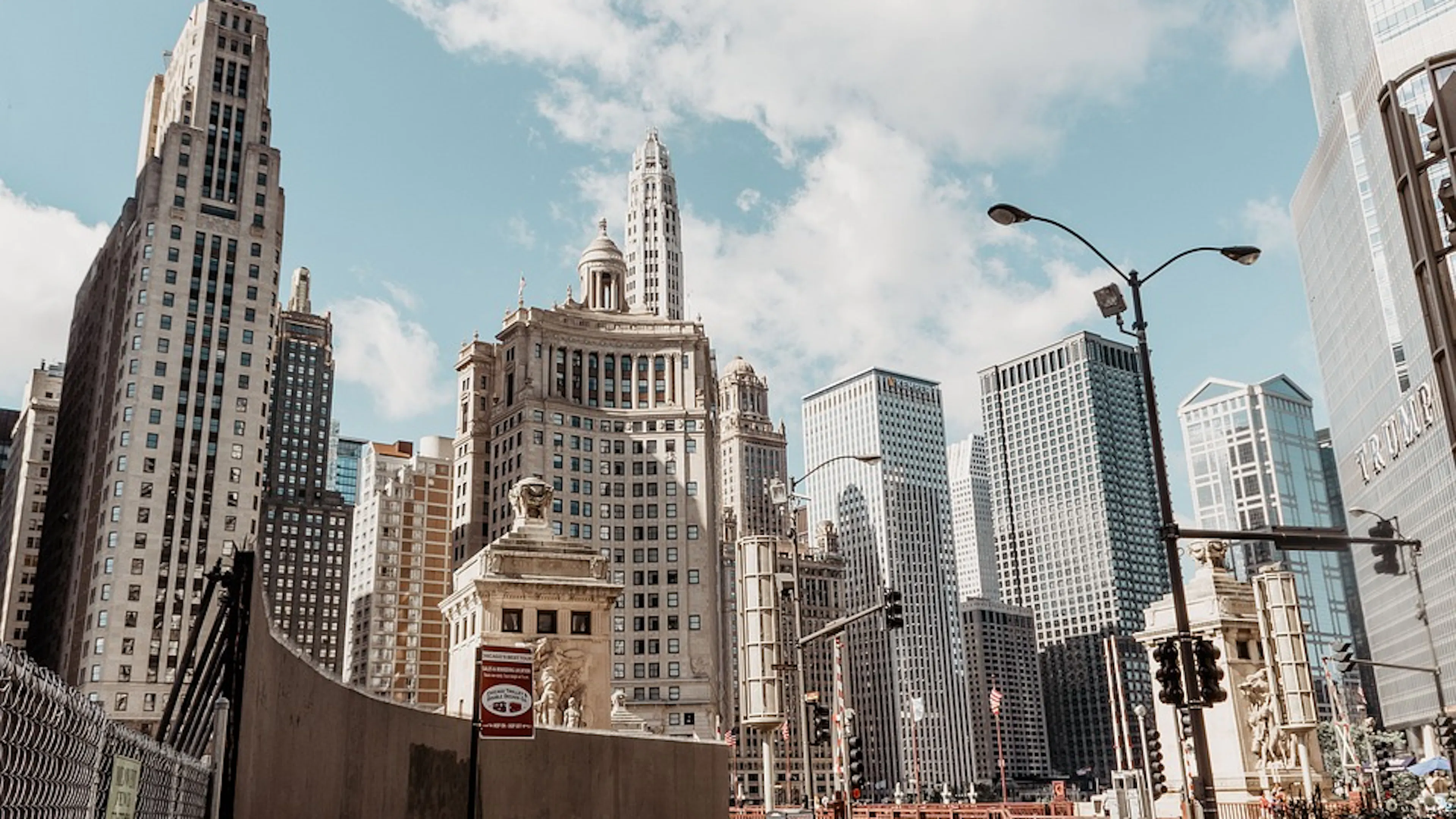 The Chicago skyline from street level bathed in a cool sunshine in front of a blue sky