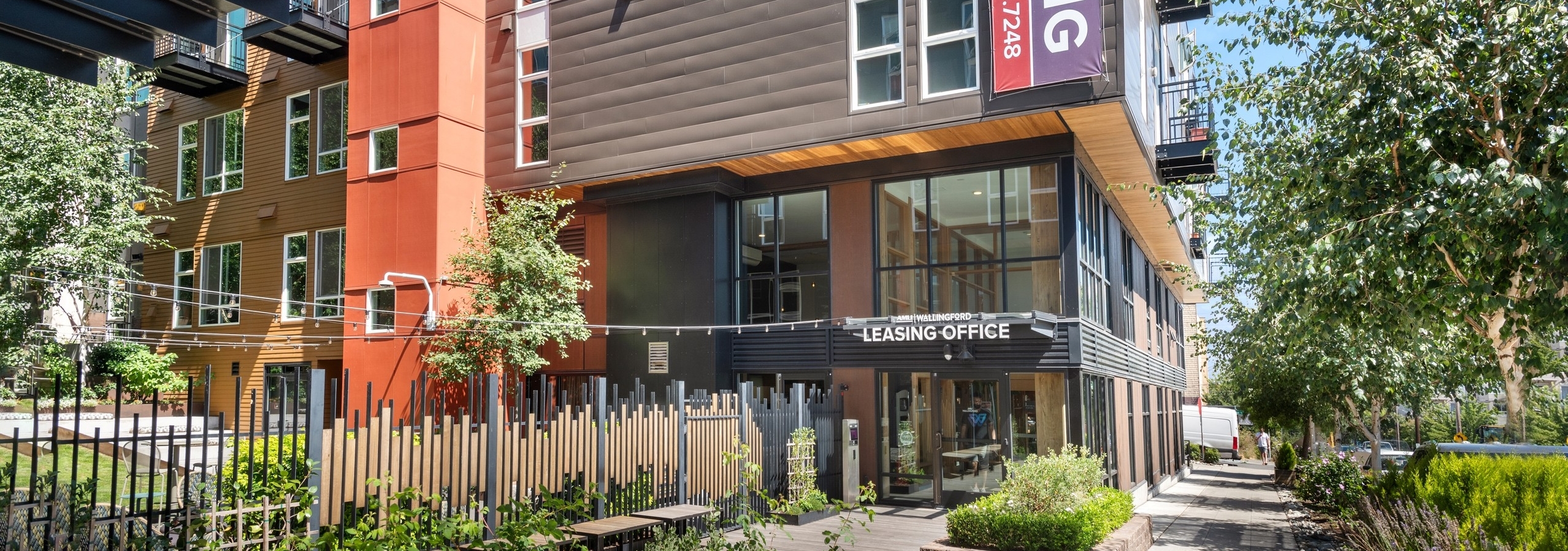 Exterior of the main entrance of AMLI Wallingford with brown facade and view of apartment balconies and courtyard