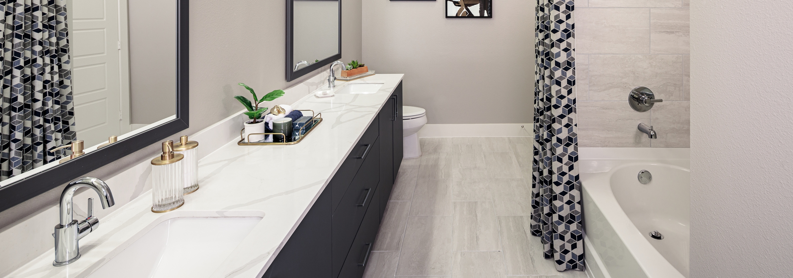 AMLI Addison bathroom with dark wood double vanity sink and garden tub with black and white curtains and pale grey tile floor