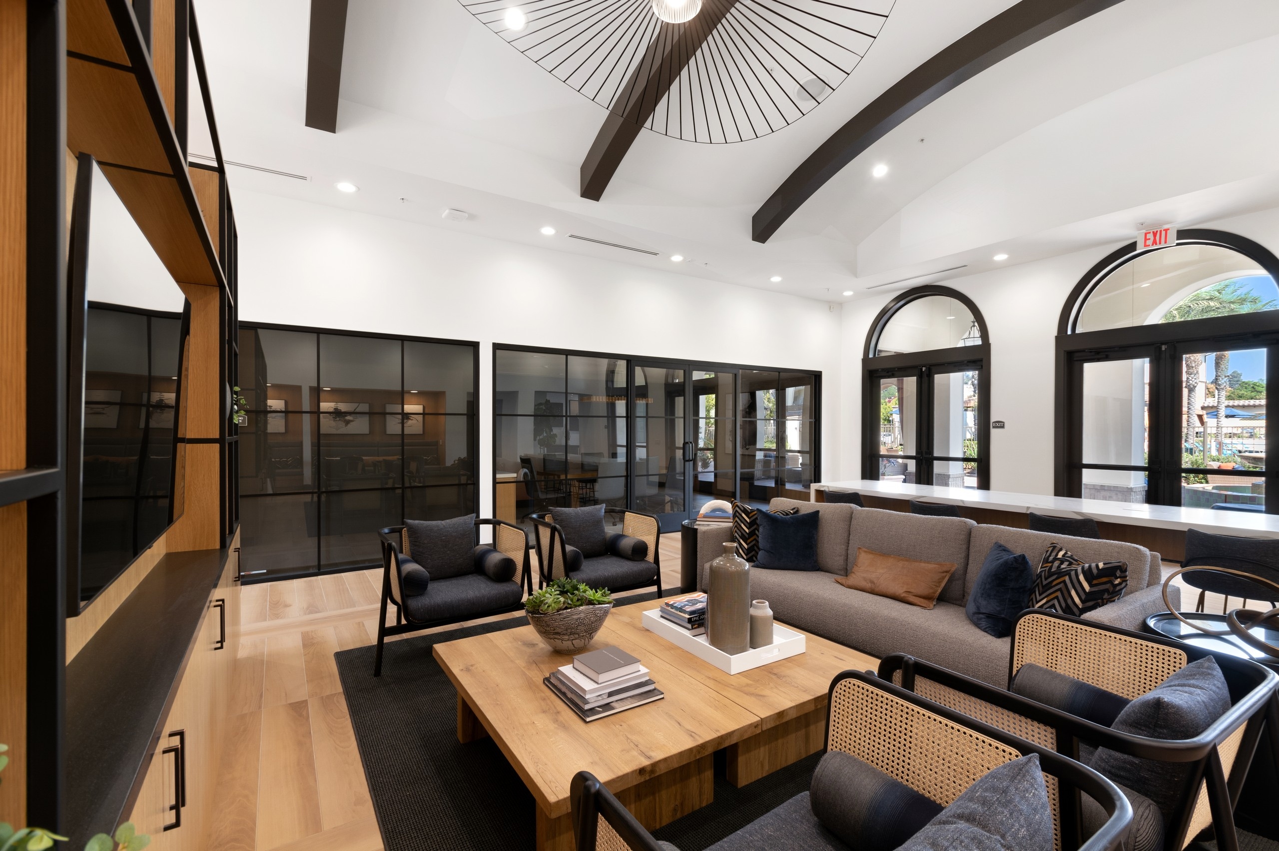 Clubhouse interior with various lounge seating and entertainment center with big screen TV at AMLI Spanish Hills apartments