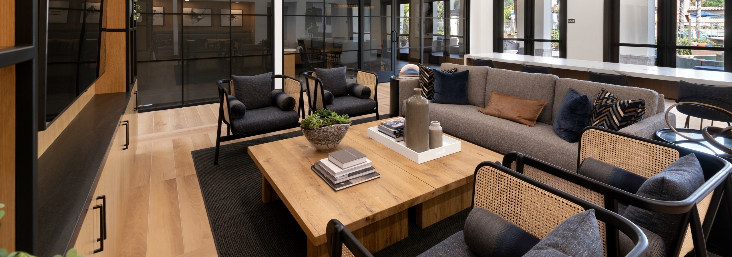 Clubhouse interior with various lounge seating and entertainment center with big screen TV at AMLI Spanish Hills apartments