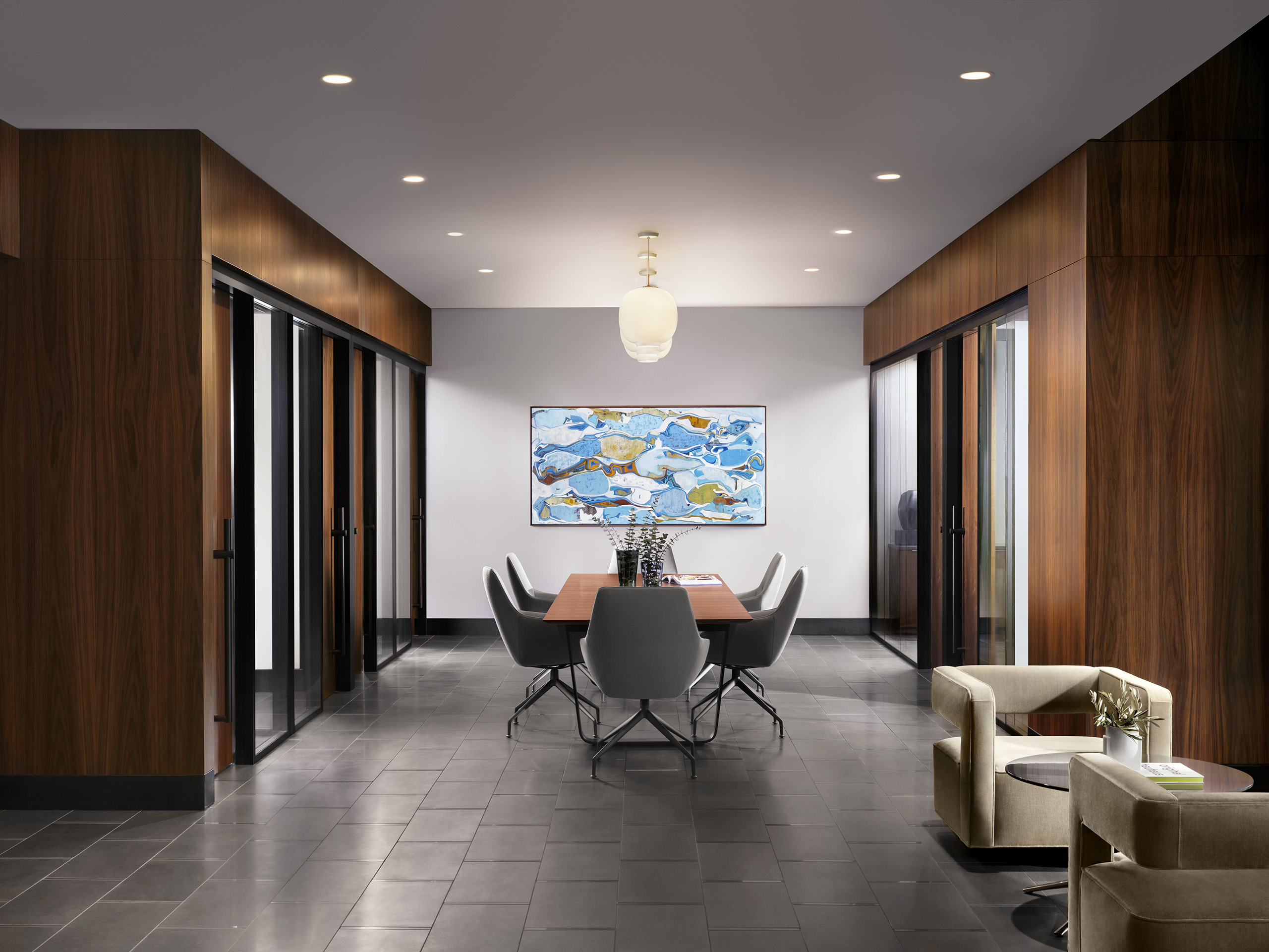Interior view of AMLI Fountain Place conference room with table and 6 chairs surrounded by private offices with glass walls
