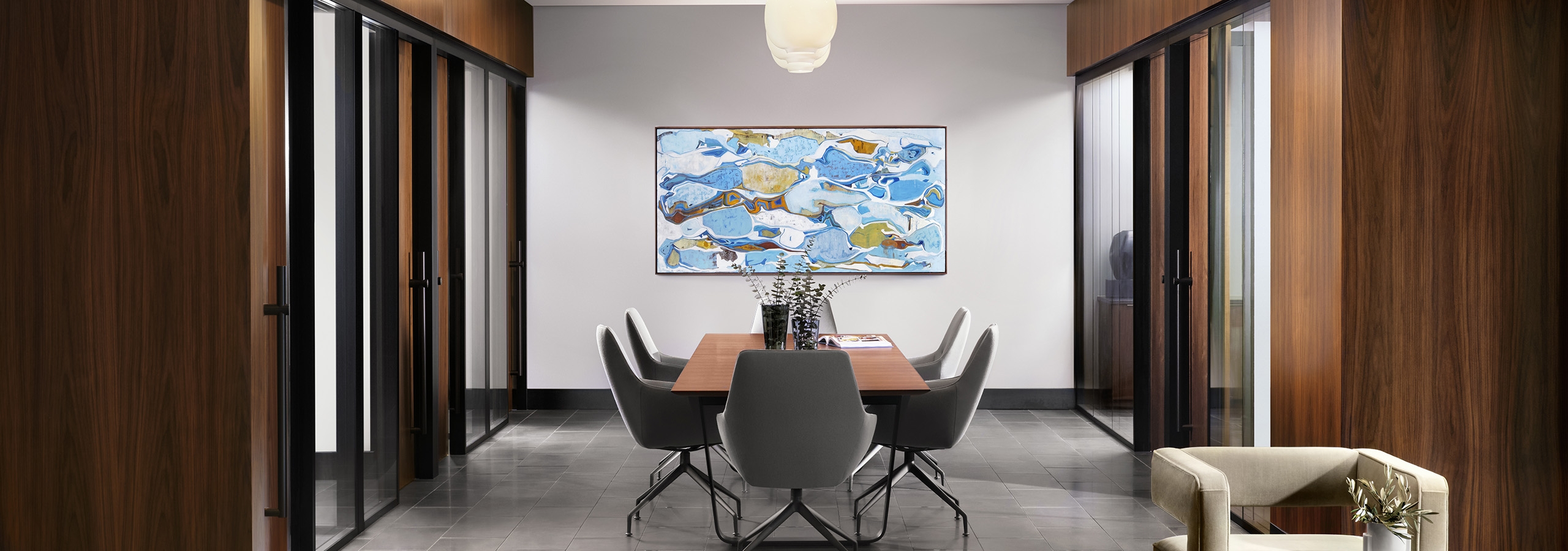 Interior view of AMLI Fountain Place conference room with table and 6 chairs surrounded by private offices with glass walls