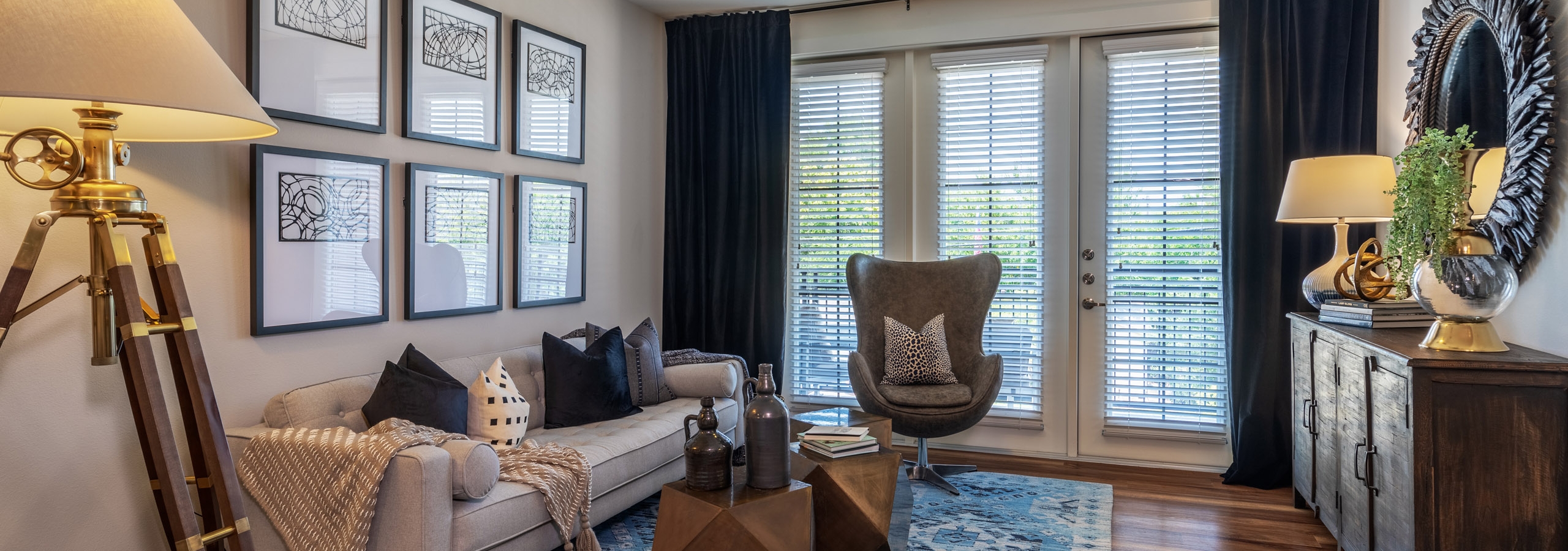 AMLI Grapevine apartment living room with hardwood floors and a private balcony and floor to ceiling windows with blinds