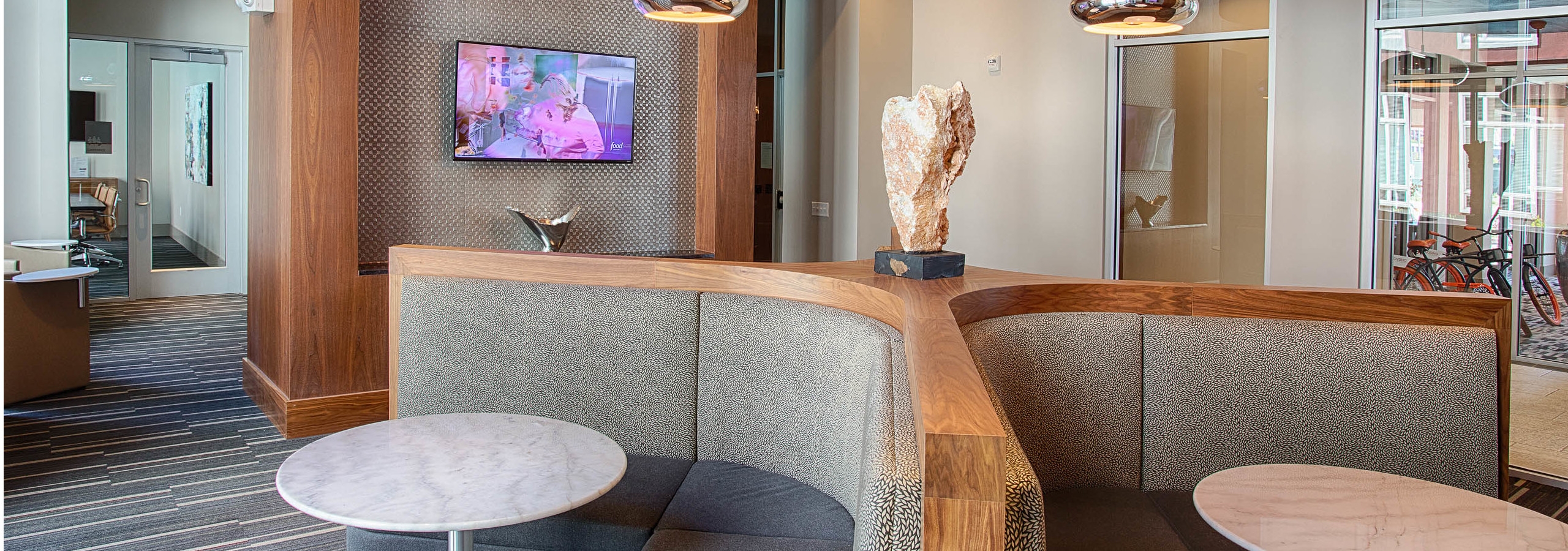 Interior view of the business center at AMLI Denargo Market apartments showcasing two padded seating areas with tables