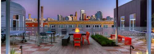 AMLI South Lake Union Rooftop deck view of downtown Seattle with fire pit seating floor lighting and lush landscaping