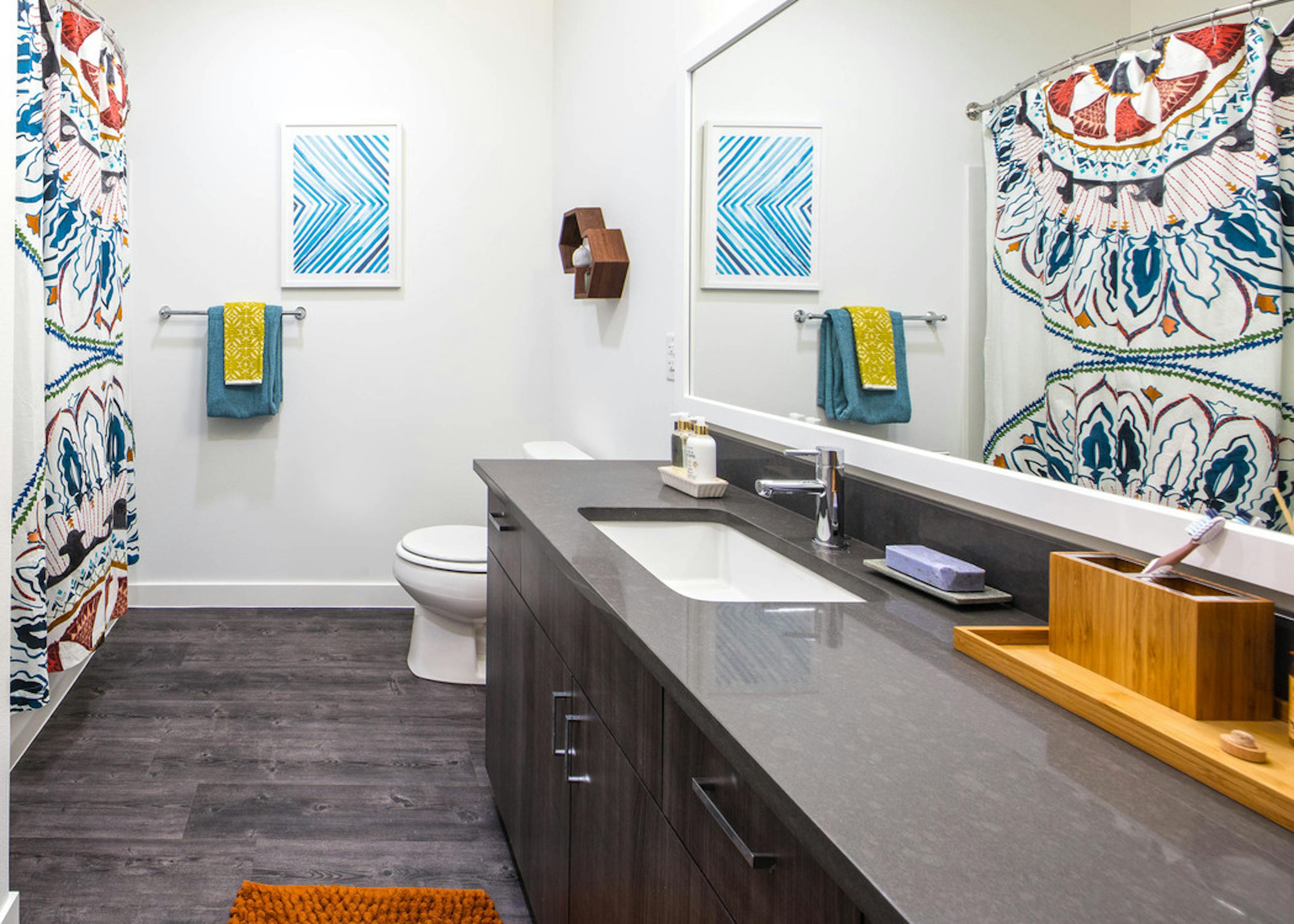 AMLI Wallingford apartment bathroom with dark quartz counter tops colorful towels and shower curtain 
