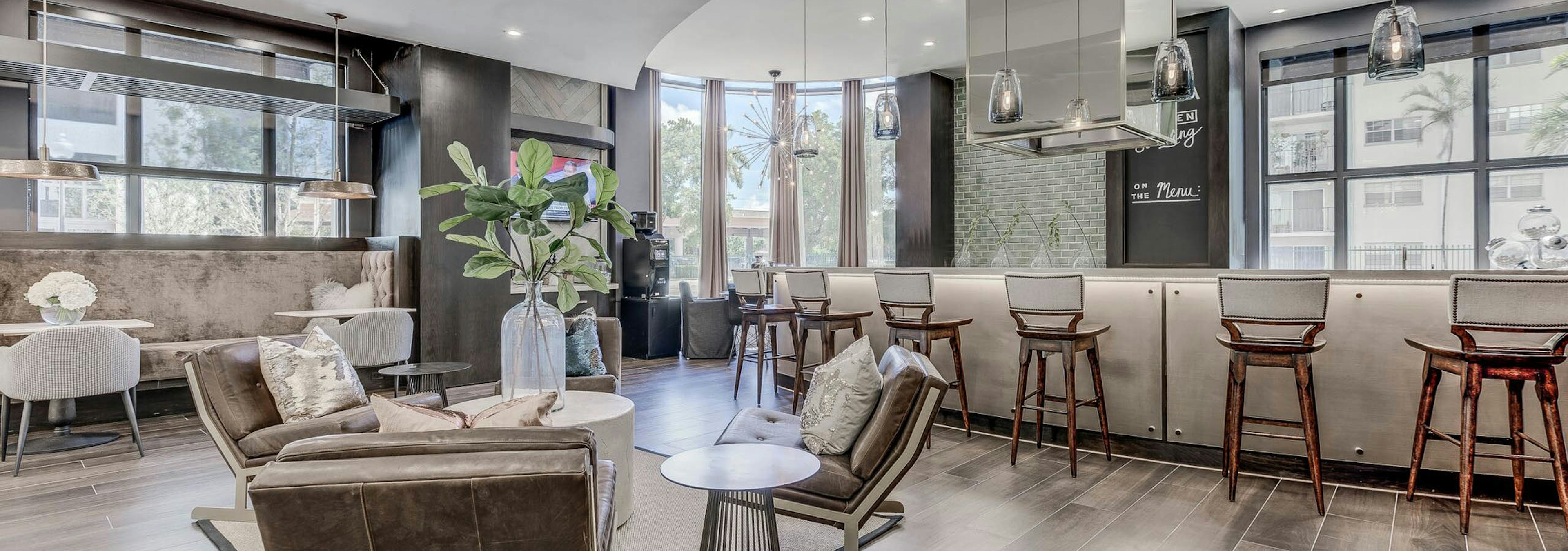 Interior view of the resident lounge at AMLI Joya apartments with modern décor, seating area and large island with stools 