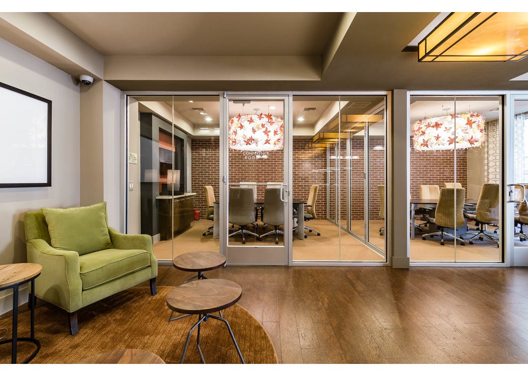 Interior view of AMLI RidgeGate conference rooms equipped with large tables and chairs, ornate chandelier and faux brick wall