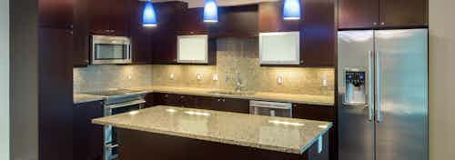 Interior view of AMLI Design District apartment kitchen with Italian-inspired cabinetry and granite countertops