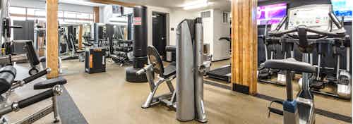 Interior of the fitness center at AMLI Wallingford with treadmills cycle bikes free weights and workout machines