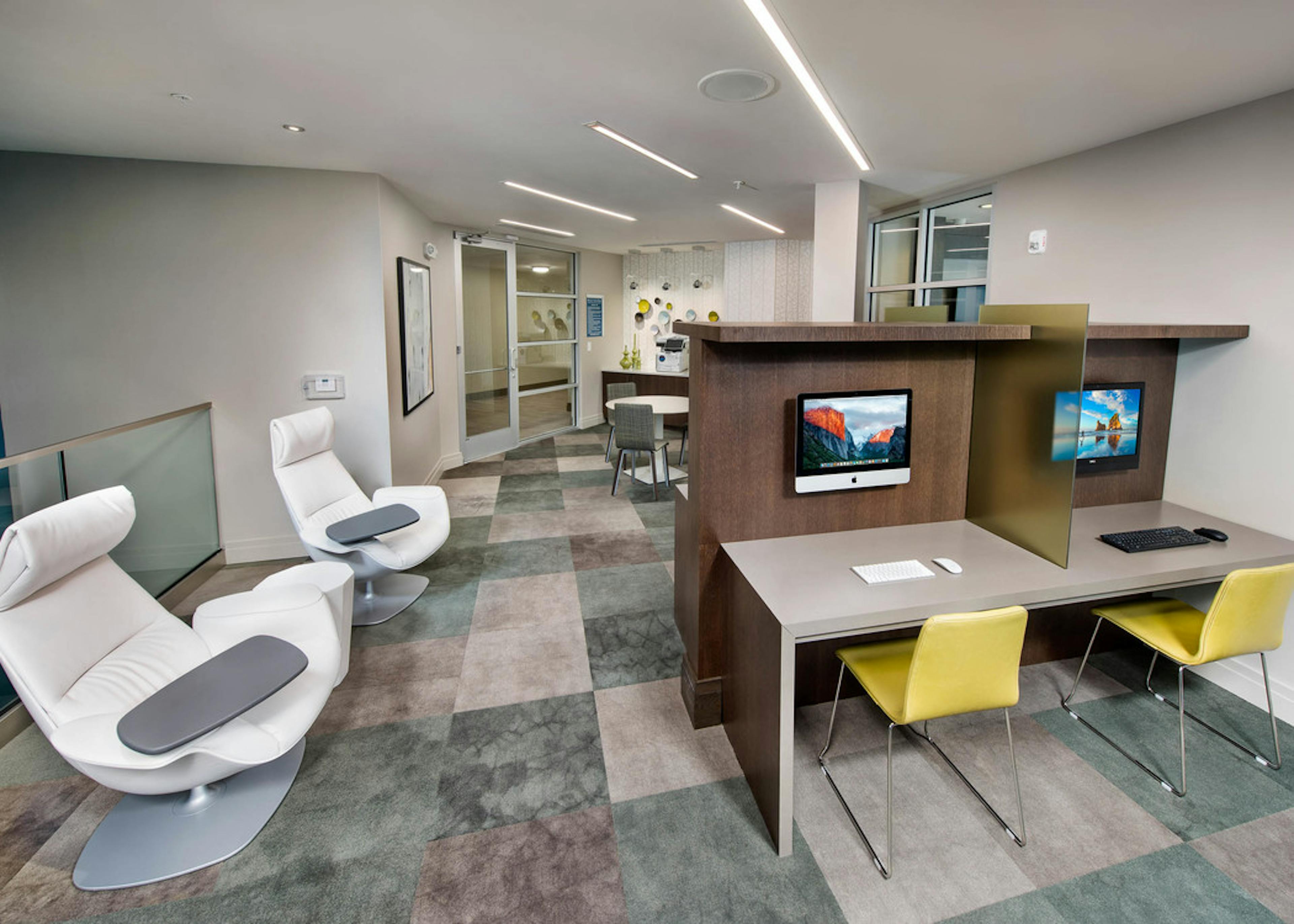 AMLI Buckhead business center with two desks with yellow chairs and a computer for each and two white node office chairs