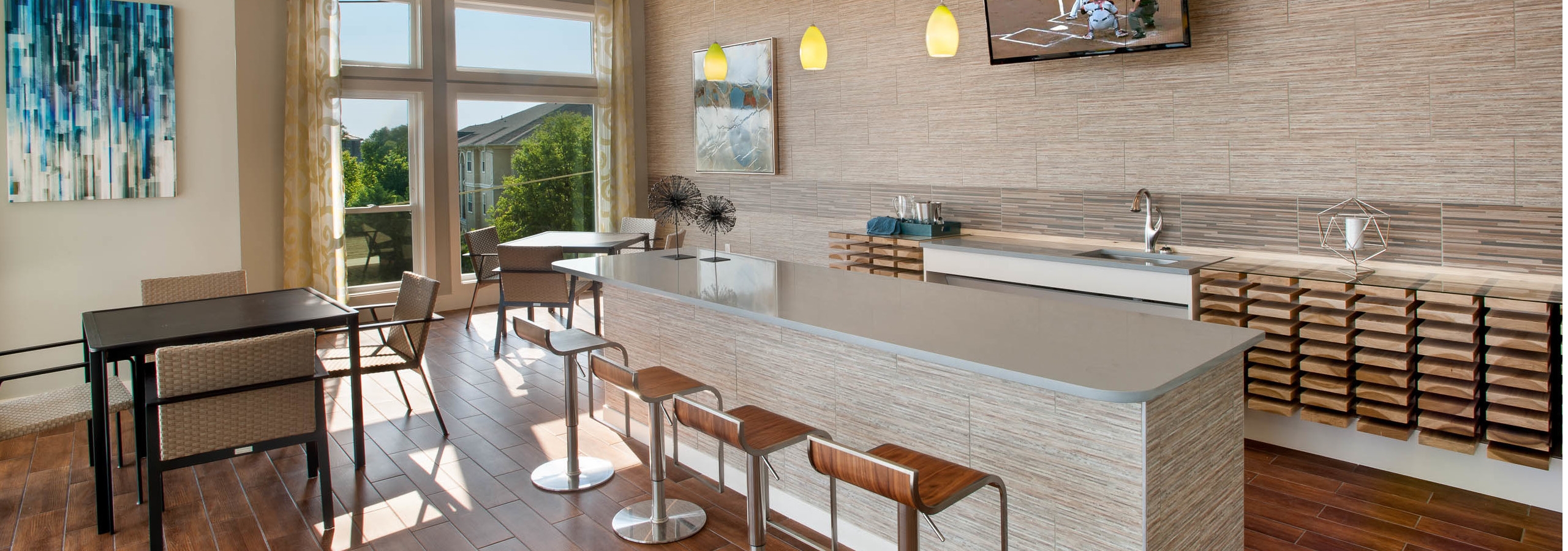 Interior view of sky lounge at AMLI Piedmont Heights apartment building with various seating areas with bar counter and TV