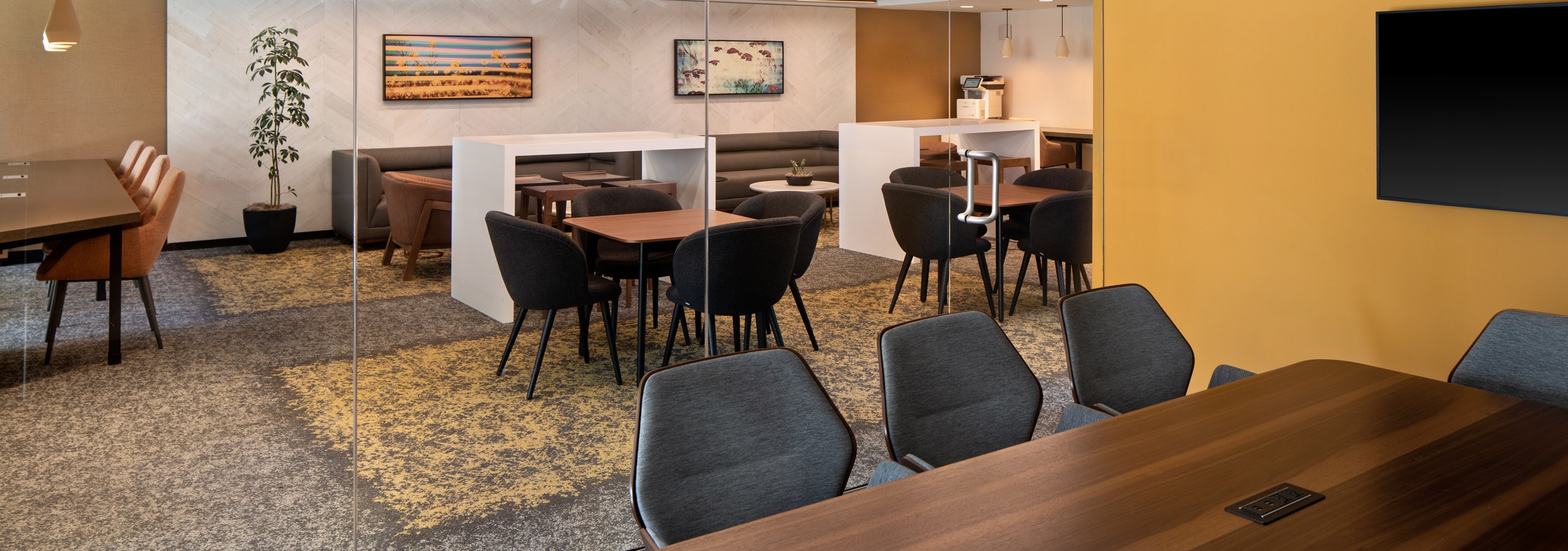 Wooden conference table at AMLI Old Pasadena apartments overlooking the business center workspaces through a glass wall