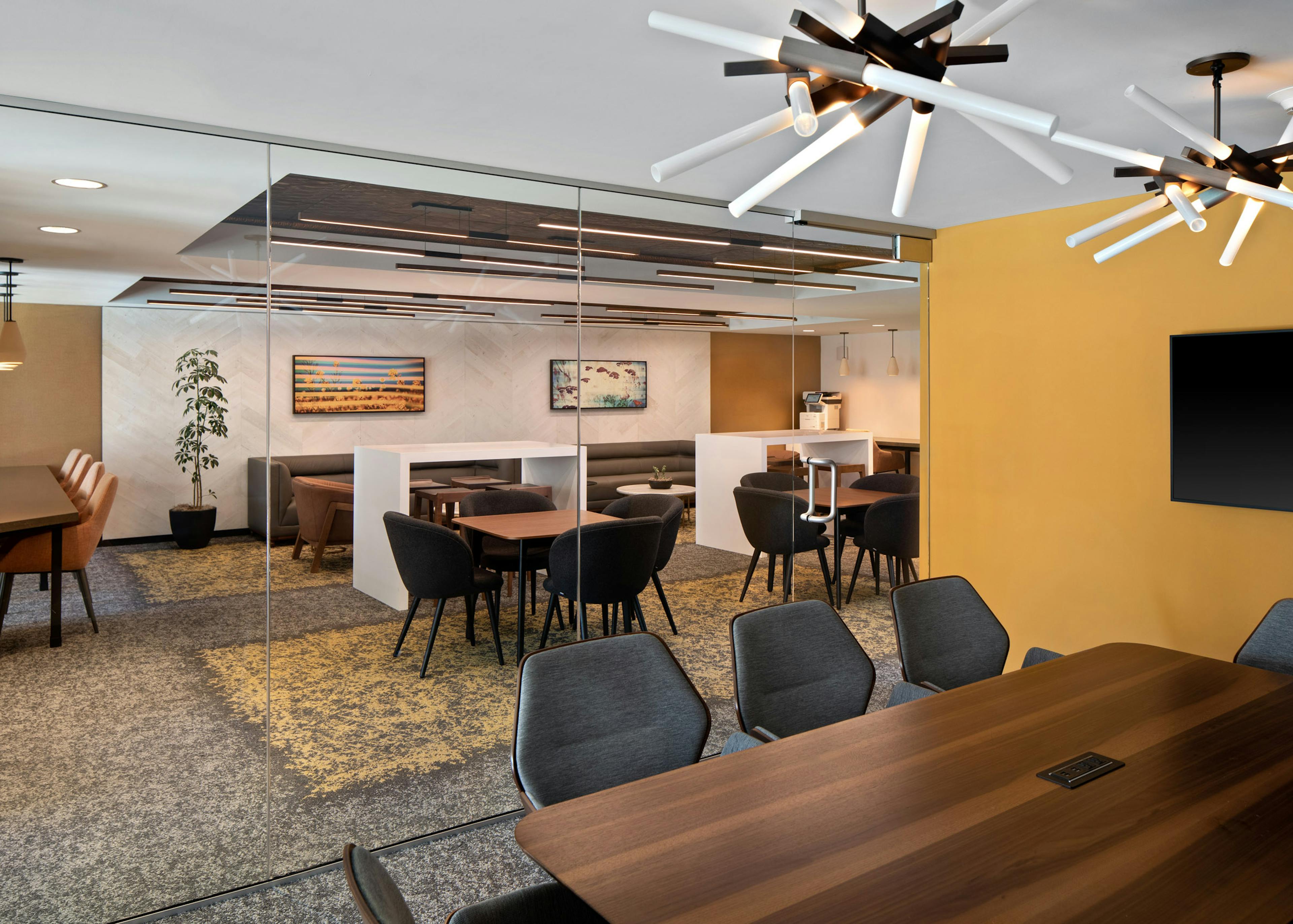 Wooden conference table at AMLI Old Pasadena apartments overlooking the business center workspaces through a glass wall